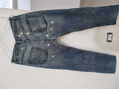 Jeans Guess da uomo con strappi e cuciture a vista. Nessun segno di manomissione e nessun difetto. 